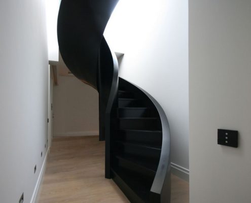 Spiralne, nowoczesne schody w korytarzu